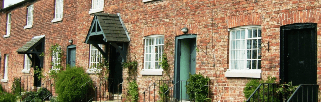 Row of brick terraced cottages with white timber sash windows