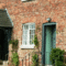 Row of brick terraced cottages with white timber sash windows